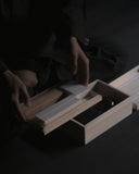 Person holding top tier of Nezen Box Set by Iwata on a Black background