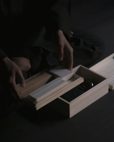 Person holding top tier of Nezen Box Set by Iwata on a Black background