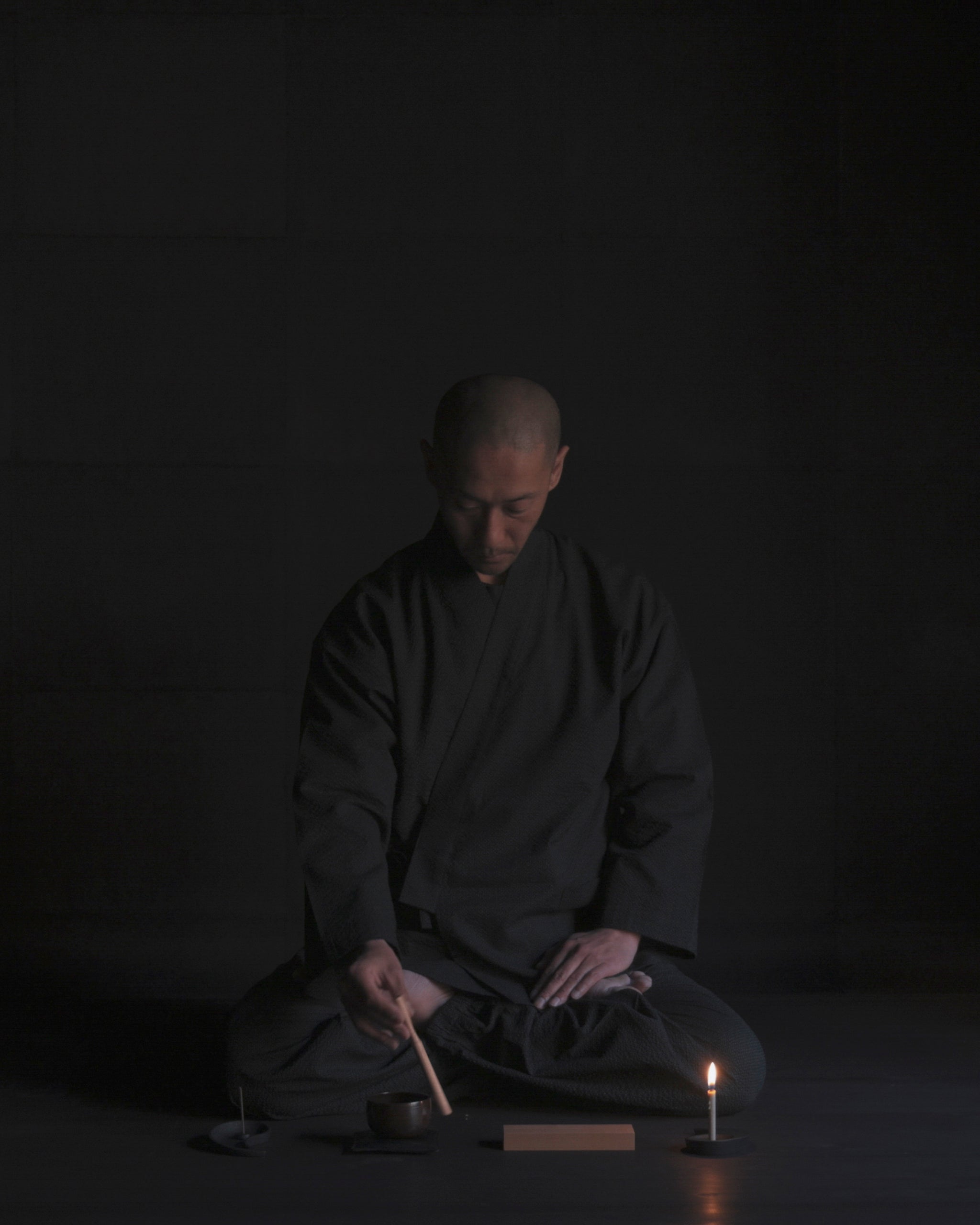 Tosei Shinabe monk wearing Samue Loungewear Set using items from Nezen Box Set by Iwata on a black background