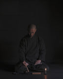 Tosei Shinabe monk wearing Samue Loungewear Set using items from Nezen Box Set by Iwata on a black background