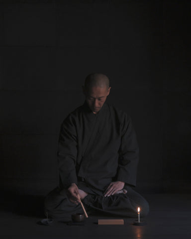 Tosei Shinabe monk wearing Samue Loungewear Set using items from Nezen Box Set by Iwata on a black background