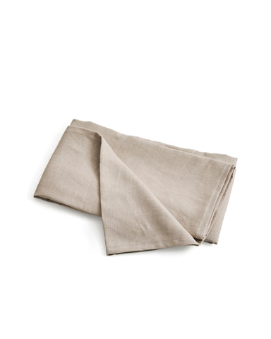Folded unbleached linen flat sheet on a white background