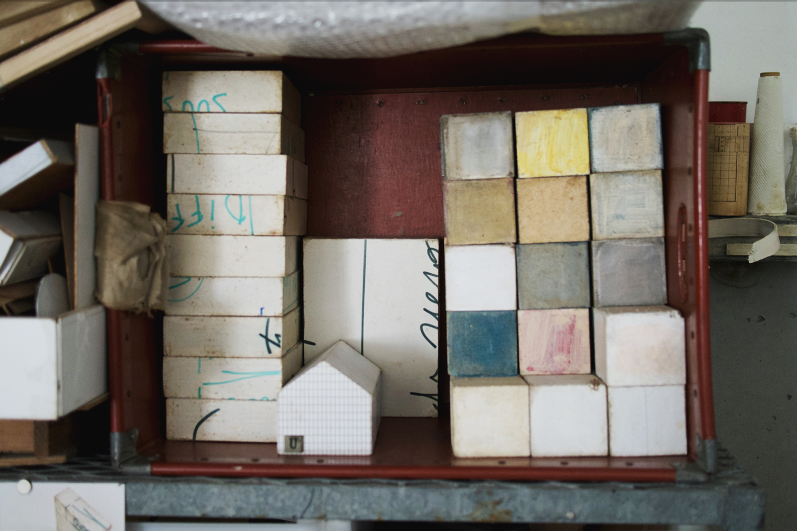 Stacked muted colourful boxes made by Michiko Iwata stacked in a shelf