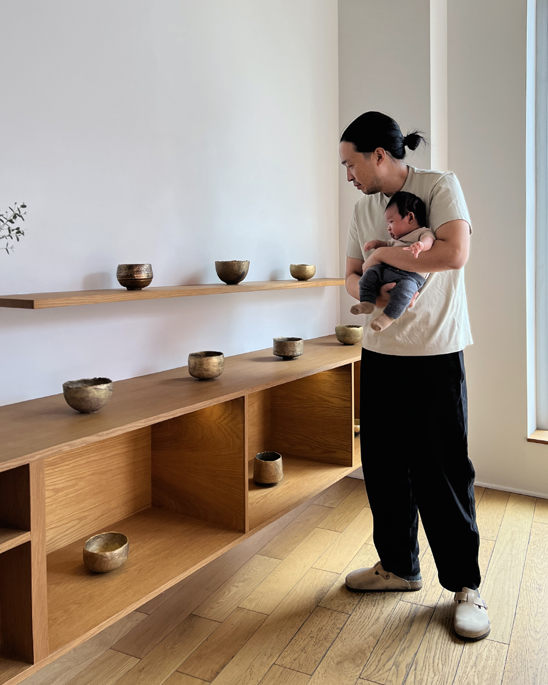 Gold chawans on display with father and baby viewing them