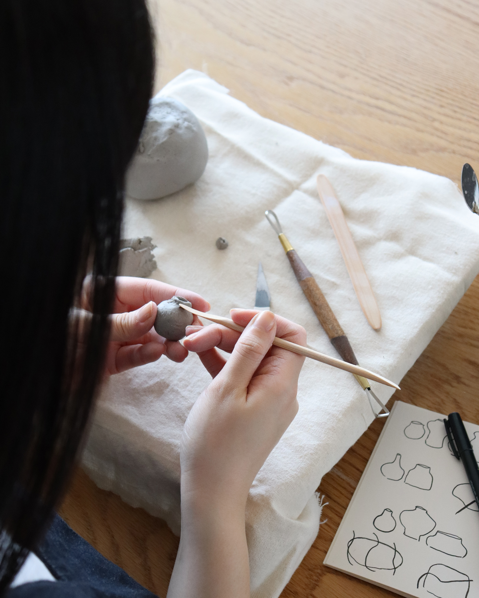 Dani Suji Lee of Dani Sujin Studio at her studio hand building mini group vases close up
