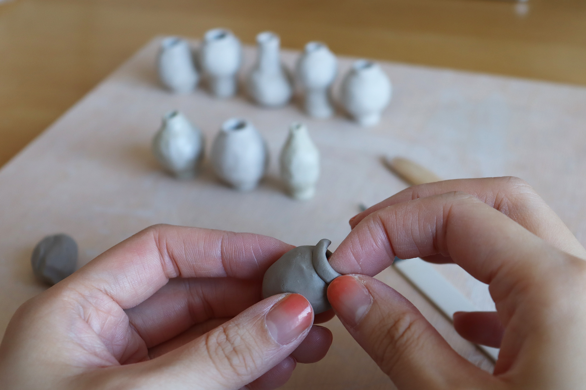 Dani Suji Lee of Dani Sujin Studio at her studio hand building mini group vases close up