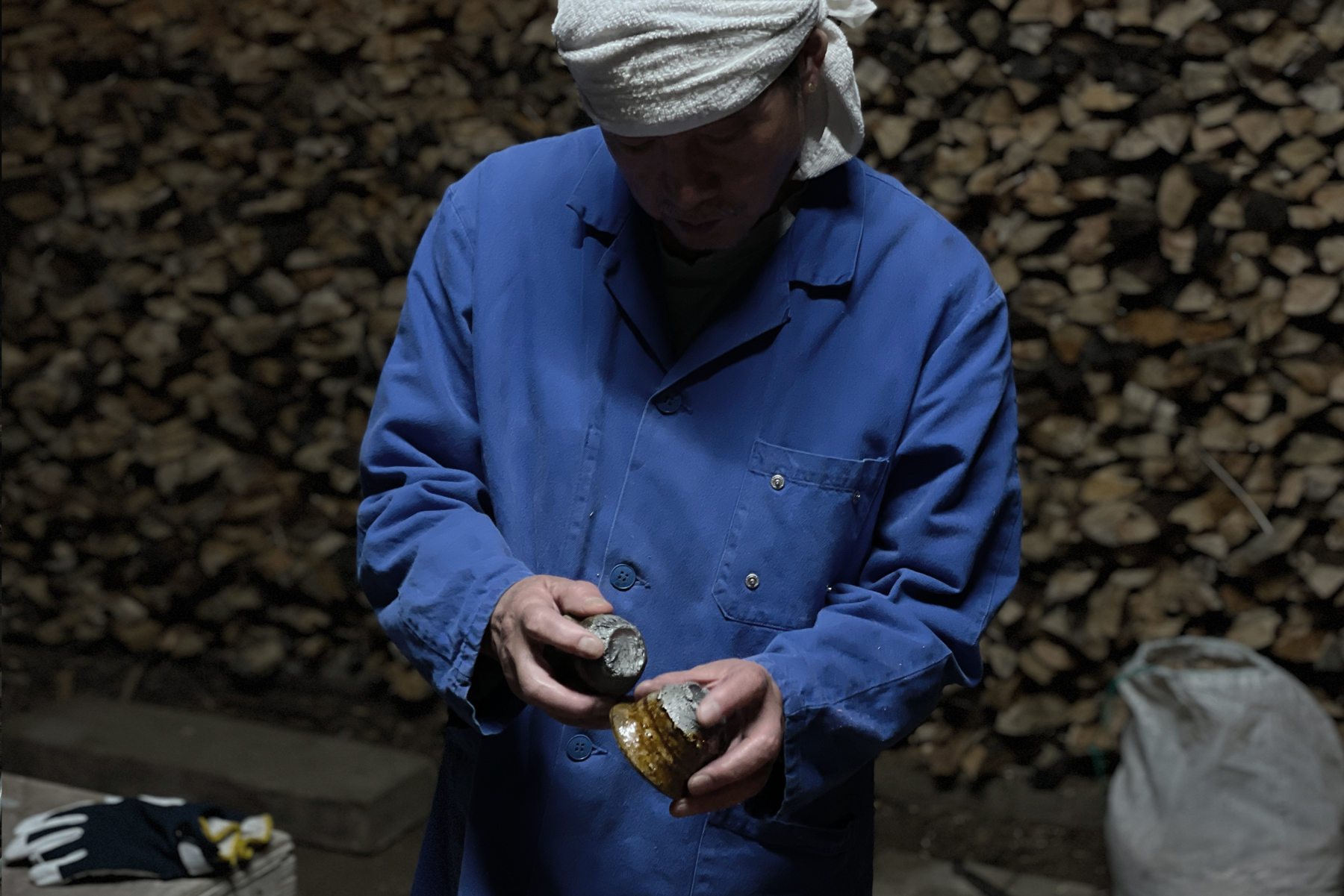 Keisuke Iwata with two anagama sake cups in his hands comparing their appearnaces