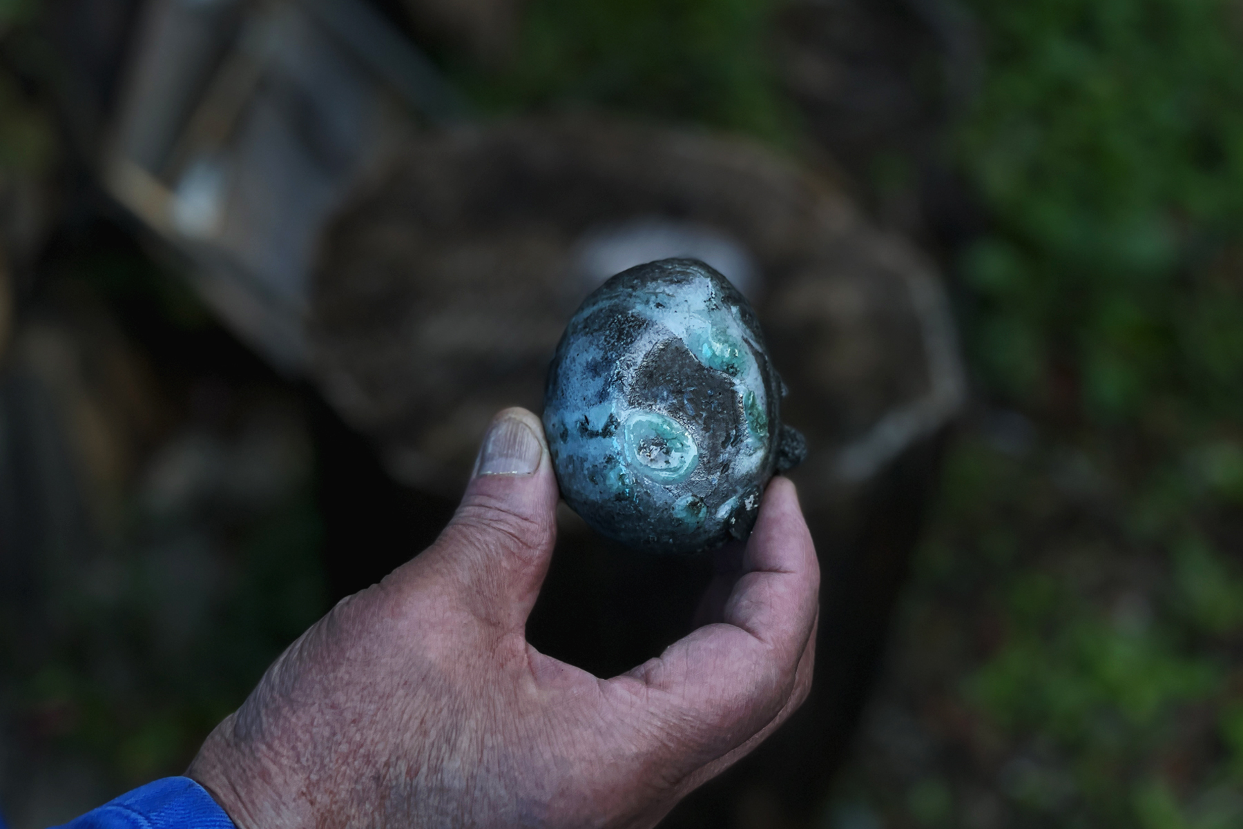Keisuke Iwata's bare hand holding up a closeup of a fire affected ceramic piece that just came out of the anagama kiln