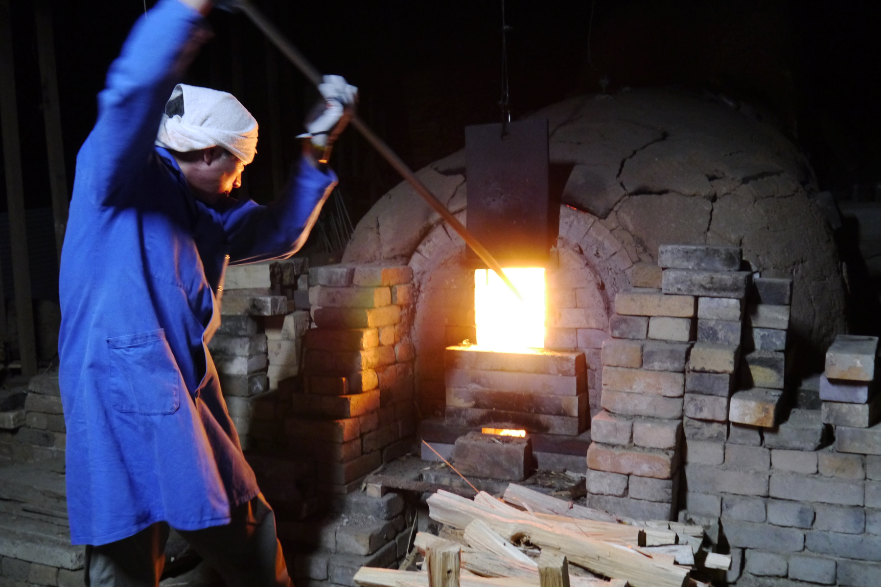 Keisuke Iwata stoking the fire of the anagama kiln