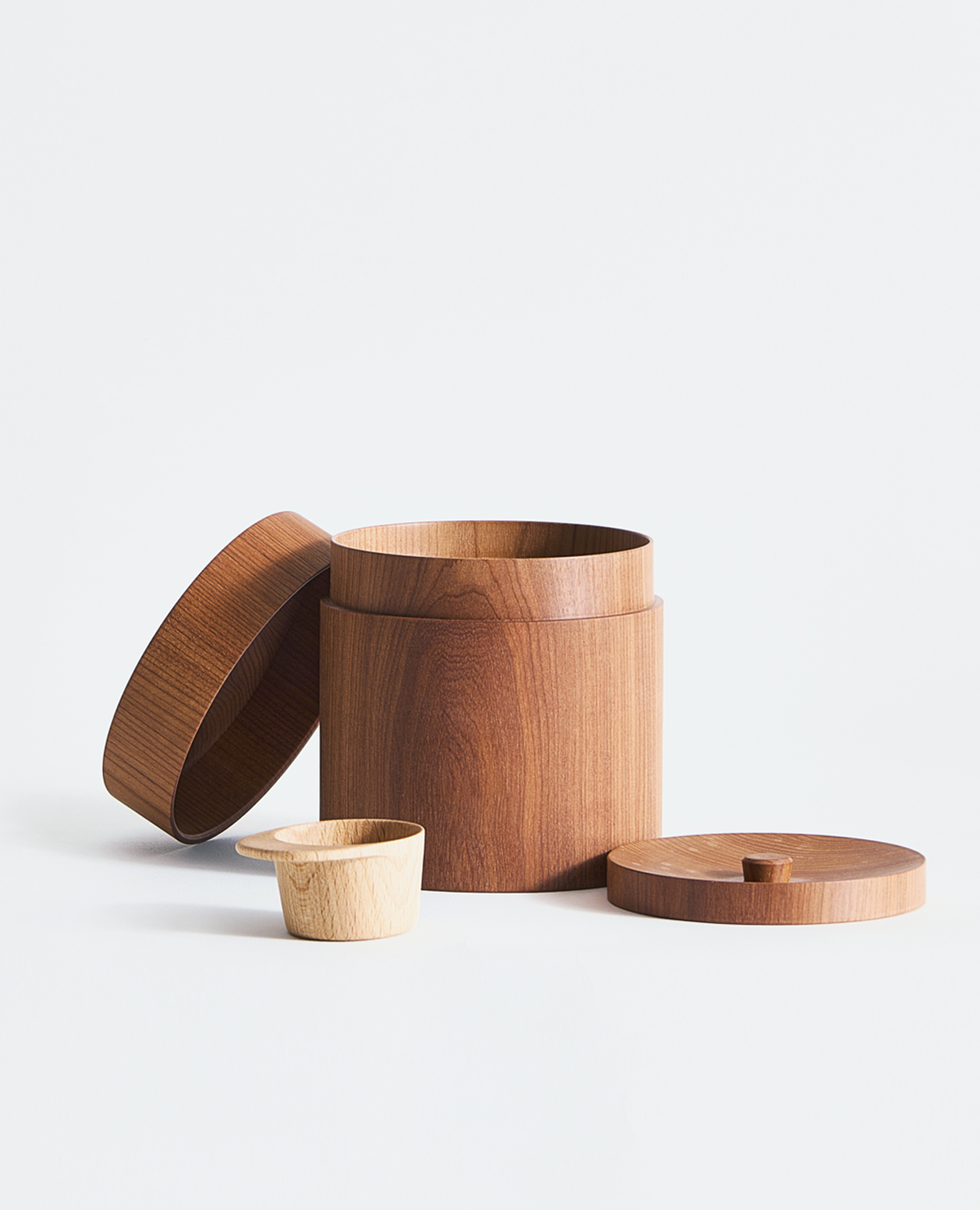Coffee canister, two lids, and a scoop by Ryuji Mitani on a gray background.