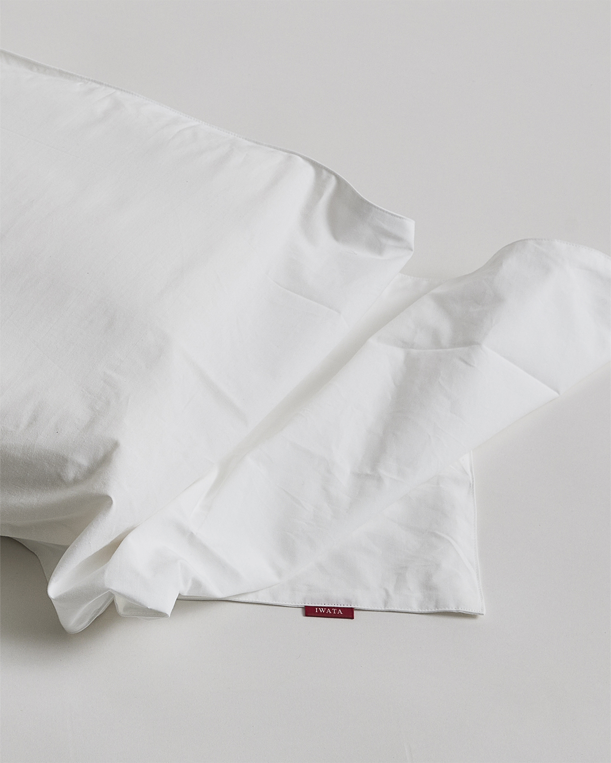 Up-close of cotton pillow sheet by Iwata on a gray background
