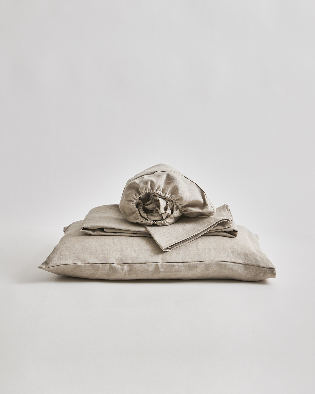 Unbleached linen sheet set by Iwata on a gray background