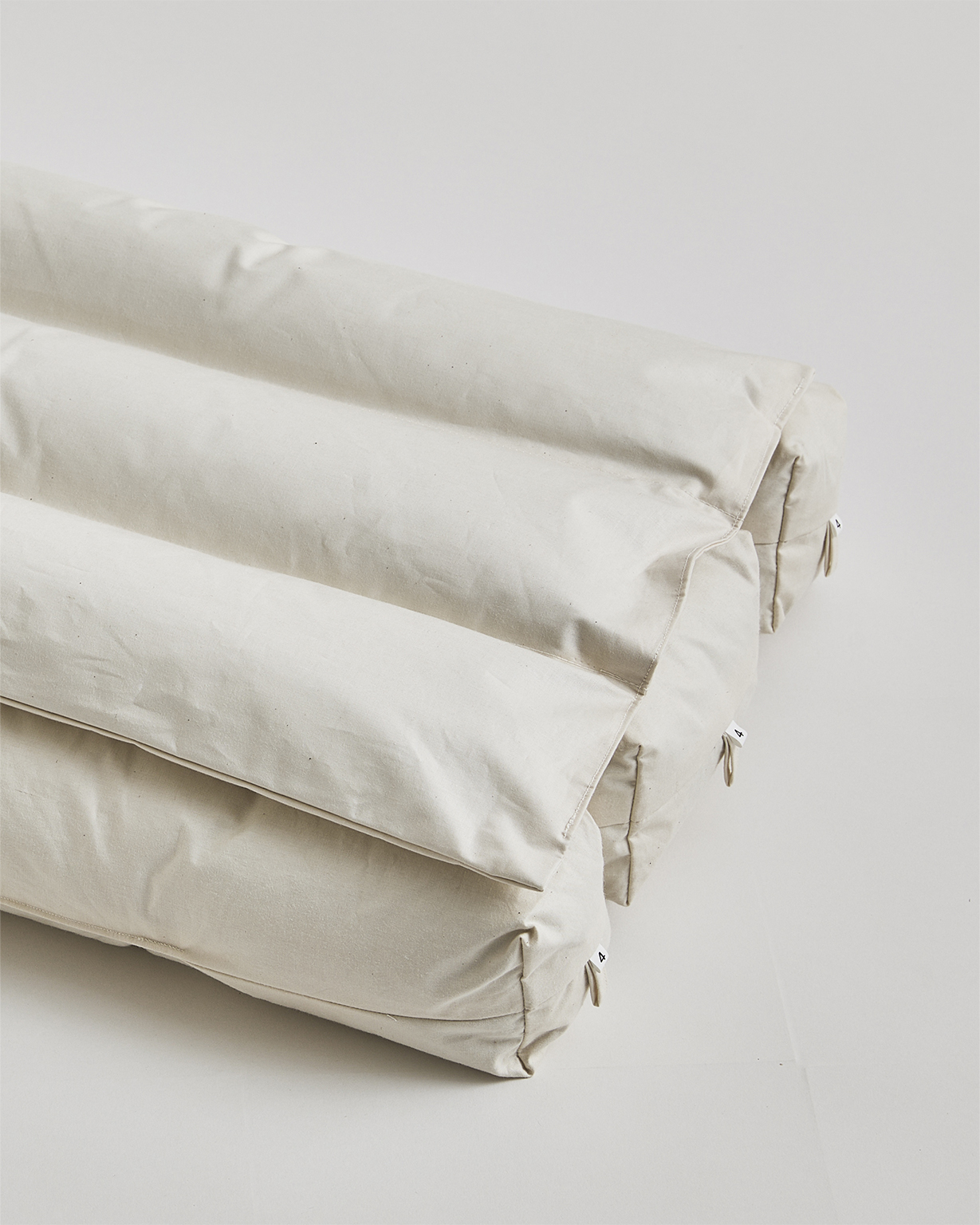 Close up of corner of interior of Camel hair pillow by Iwata on a gray background