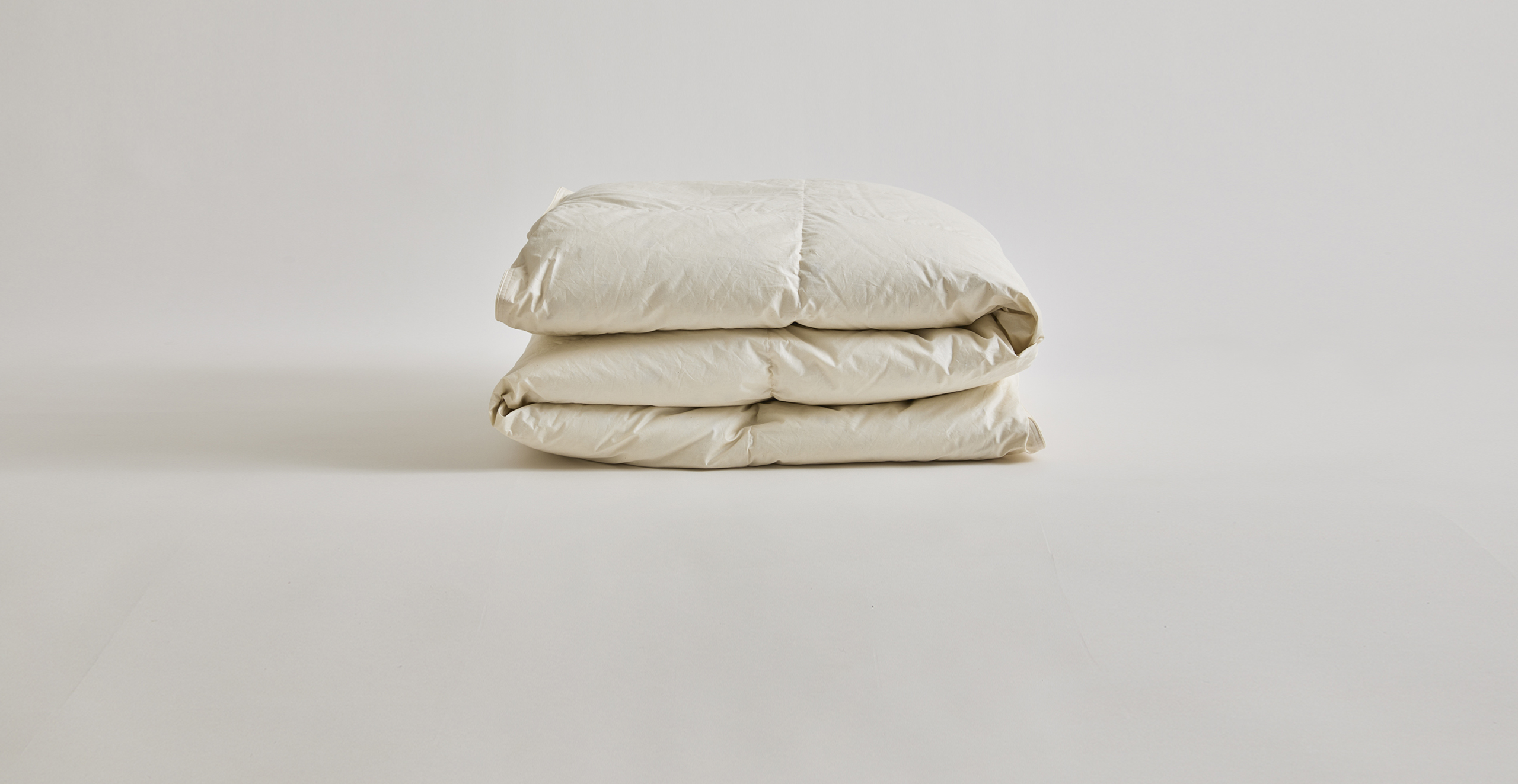 Unbleached white rolled up down duvet by Iwata