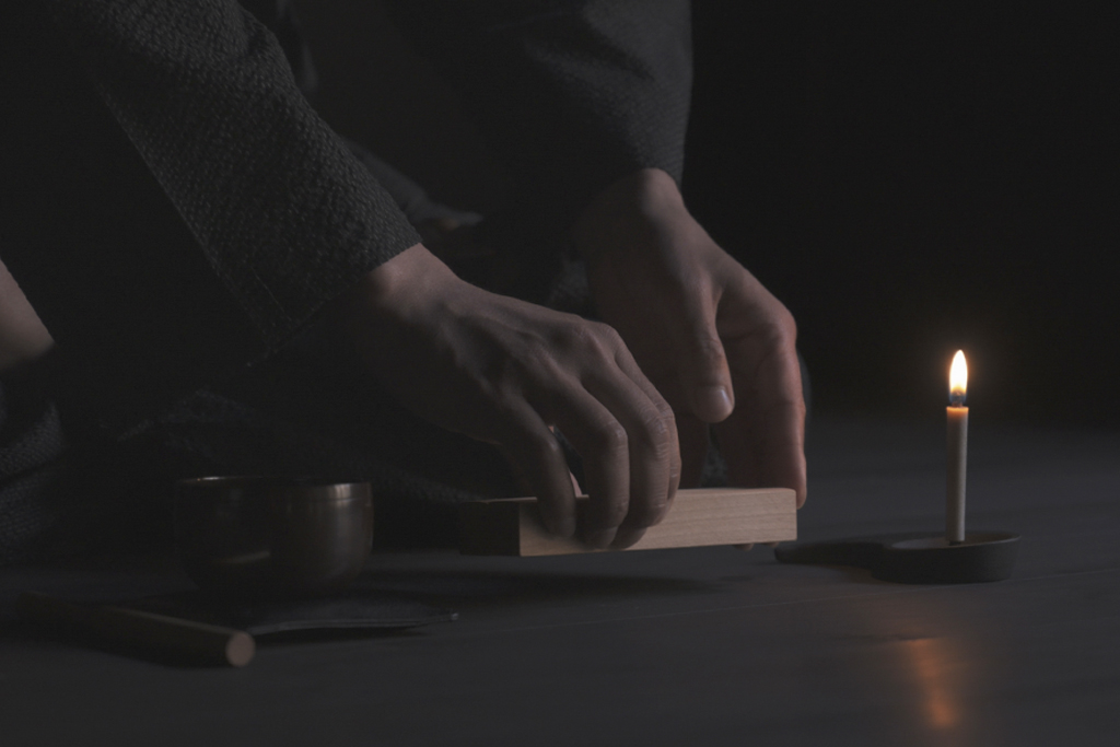 Hands picking up Meditation Clappers from the Nezen Boxed Set by Iwata on the ground.